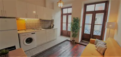 a kitchen with a washing machine and a living room at Clérigos City Heart Flat in Porto