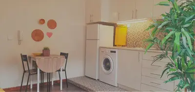a kitchen with a washing machine and a table with chairs at Clérigos City Heart Flat in Porto