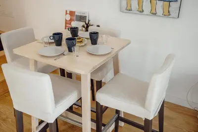 a wooden table with white chairs and a table with food on it at OPORTO GUEST Lotte House in Porto