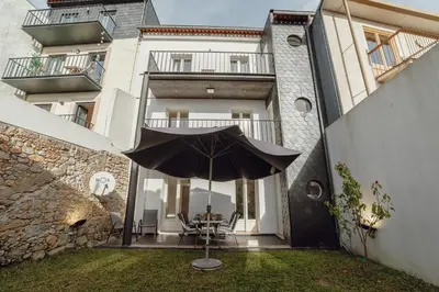 a patio with an umbrella in front of a building at OPORTO GUEST Lotte House in Porto