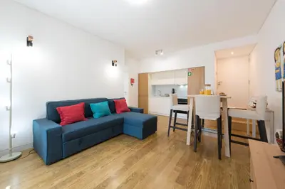 a living room with a blue couch with colorful pillows at OPORTO GUEST Lotte House in Porto
