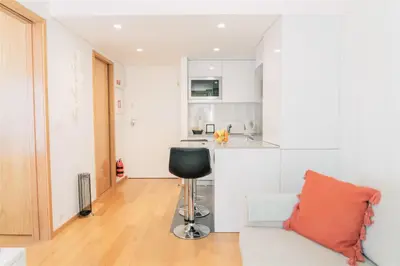 a living room with a chair and a kitchen at Oporto Yellow Apartments in Porto