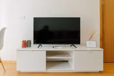 a white entertainment center with a television on top at Oporto Yellow Apartments in Porto