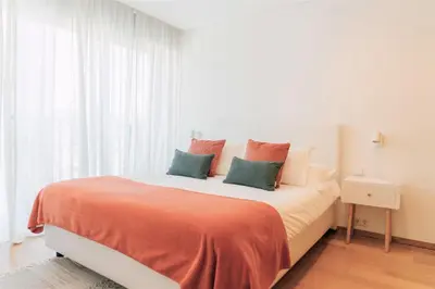 a bedroom with a large bed with orange and green pillows at Oporto Yellow Apartments in Porto