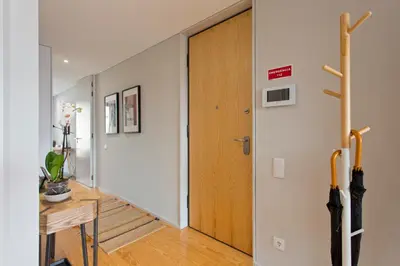 a hallway with a wooden door and a table at Balconies of Cedofeita & Garage in Porto