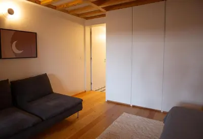 a living room with a couch and a closet at Batalha Garden Apartment in Porto