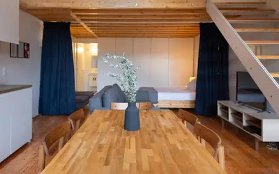 a dining room with a table and a couch at Batalha Garden Apartment in Porto