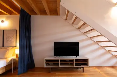 a living room with a tv and a staircase at Batalha Garden Apartment in Porto