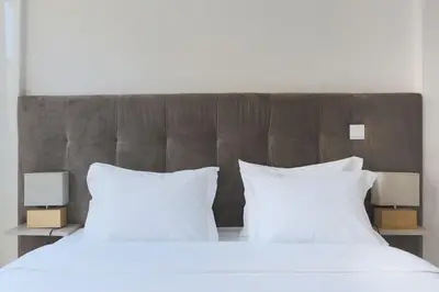 a bed with two white pillows and two lamps at Marquês Deluxe Apartments 3 & 4 in Porto