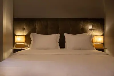 a large bed with white pillows and two lamps at Marquês Deluxe Apartments 3 & 4 in Porto