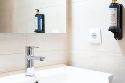 a bathroom sink with a soap dispenser on the wall at Marquês Deluxe Apartments 3 & 4 in Porto