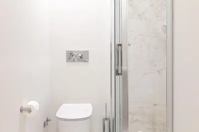 a bathroom with a toilet and a glass shower door at VIVA Whilom Secret with garage in Porto