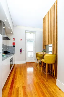 a kitchen with a table and yellow chairs in a room at Mouzinho 129 - Medronheiro & Oliveira in Porto