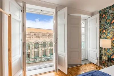 a bedroom with a large bed with a floral wallpaper at São Bento Deluxe 42 with Balcony in Porto