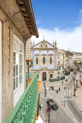 a bedroom with a blue bed with a floral wallpaper at São Bento Deluxe 42 with Balcony in Porto
