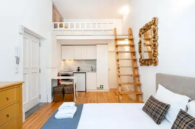 a small bedroom with a bed and a kitchen at VIVA Library Studio in Porto