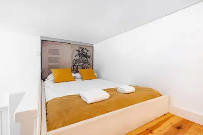 a bedroom with a bed with two pillows on it at VIVA Library Studio in Porto