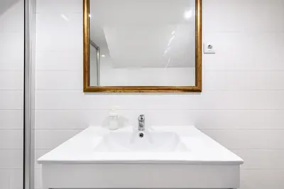 a bathroom with a white sink and a mirror at VIVA Library Studio in Porto