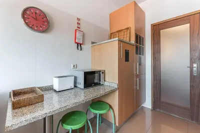 a kitchen with a counter and two green stools at GuestReady - Warwick avenue in Lapa in Porto