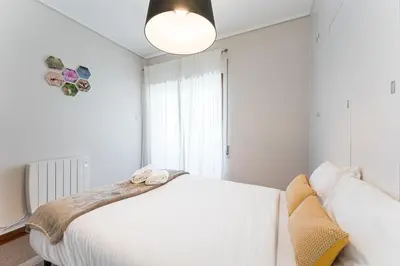 a bedroom with a white bed and a light fixture at GuestReady - Warwick avenue in Lapa in Porto