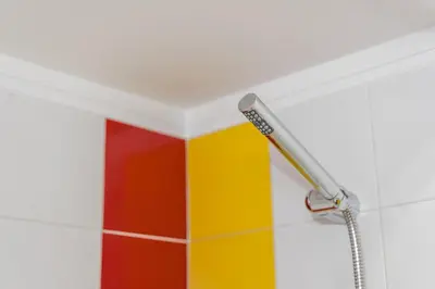 a shower head in a bathroom with colorful tiles at GuestReady - Warwick avenue in Lapa in Porto