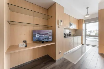a living room with a tv on a wooden wall at GuestReady - Antas Studio in Porto