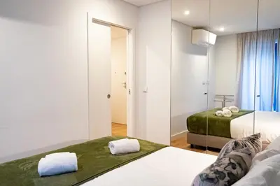 a hotel room with two beds and a mirror at N&N Home in Porto