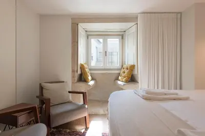 a bedroom with a bed and a chair and a window at Classy & Stylish Porto Duplex in Porto