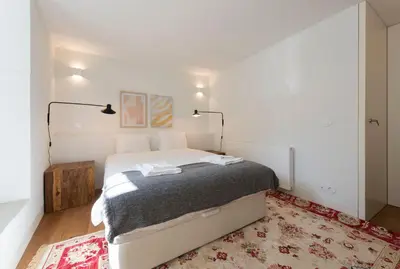a bedroom with a bed and two lamps and a rug at Classy & Stylish Porto Duplex in Porto