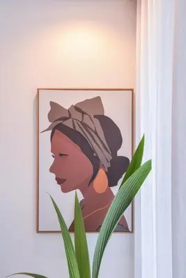 a picture of a woman on a wall next to a plant at Oporto lovely house deluxe in Porto