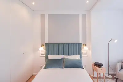 a bedroom with a bed with a blue headboard at Oporto lovely house deluxe in Porto