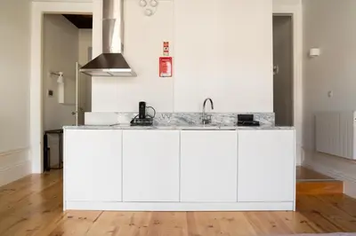 a kitchen with white cabinets and a sink at Sky de Loios in Porto
