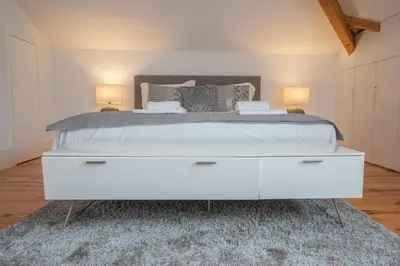 a bedroom with a large white bed with two lamps at Tomas Loft in Porto