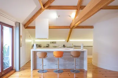 a kitchen with a counter and two stools at Tomas Loft in Porto