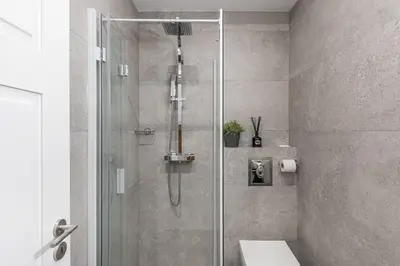 a bathroom with a shower with a toilet and a sink at GuestReady - Chakra Duplex in Porto