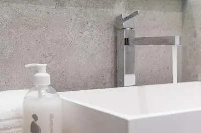 a bottle of soap sitting next to a bathroom sink at GuestReady - Chakra Duplex in Porto