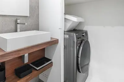 a bathroom with a sink and a washing machine at GuestReady - Chakra Duplex in Porto