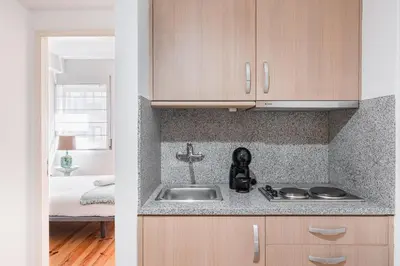 a kitchen with a sink and a room with a bed at GuestReady - Riber Porto Apts in Porto