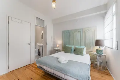 a bedroom with a large bed and a bathroom at GuestReady - Riber Porto Apts in Porto