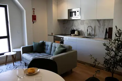 a living room with a couch and a kitchen at Casa do Paraiso - City Center Gem (w/ AC) by LovelyStay in Porto