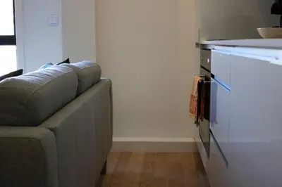 a living room with a couch and a kitchen at Casa do Paraiso - City Center Gem (w/ AC) by LovelyStay in Porto