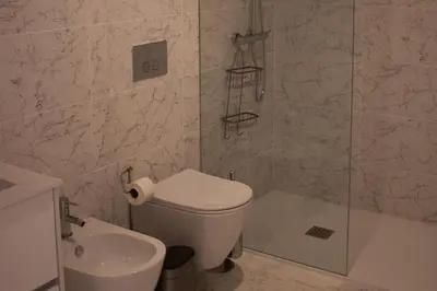 a bathroom with a toilet and a shower and a sink at Casa do Paraiso - City Center Gem (w/ AC) by LovelyStay in Porto
