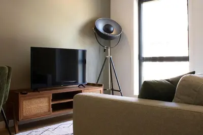 a living room with a couch and a flat screen tv at Casa do Paraiso - City Center Gem (w/ AC) by LovelyStay in Porto
