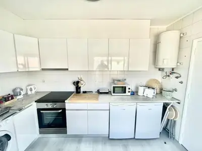 a white kitchen with white cabinets and a microwave at Apartamento Paradise Porto in Porto