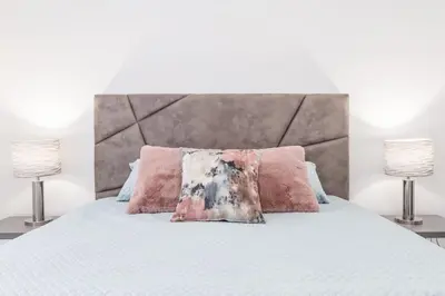 a white bed with pink pillows and two lamps at Apartamento Paradise Porto in Porto
