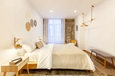 a white bedroom with a large bed and a table at D&S - Alegria 630 in Porto