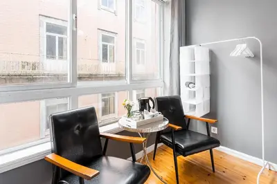 a table and chairs in a room with windows at GuestReady - Gold Leaf in Porto