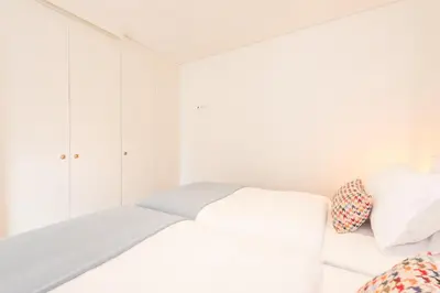 a white bedroom with a white bed and pillows at 12 Sweet Caroline in Porto