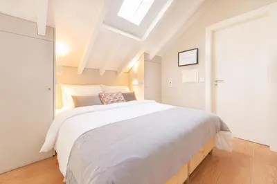 a bedroom with a large white bed with a skylight at 12 Sweet Caroline in Porto