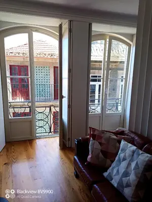 a living room with a couch and two large windows at Oporto Apartment Sé Catedral in Porto